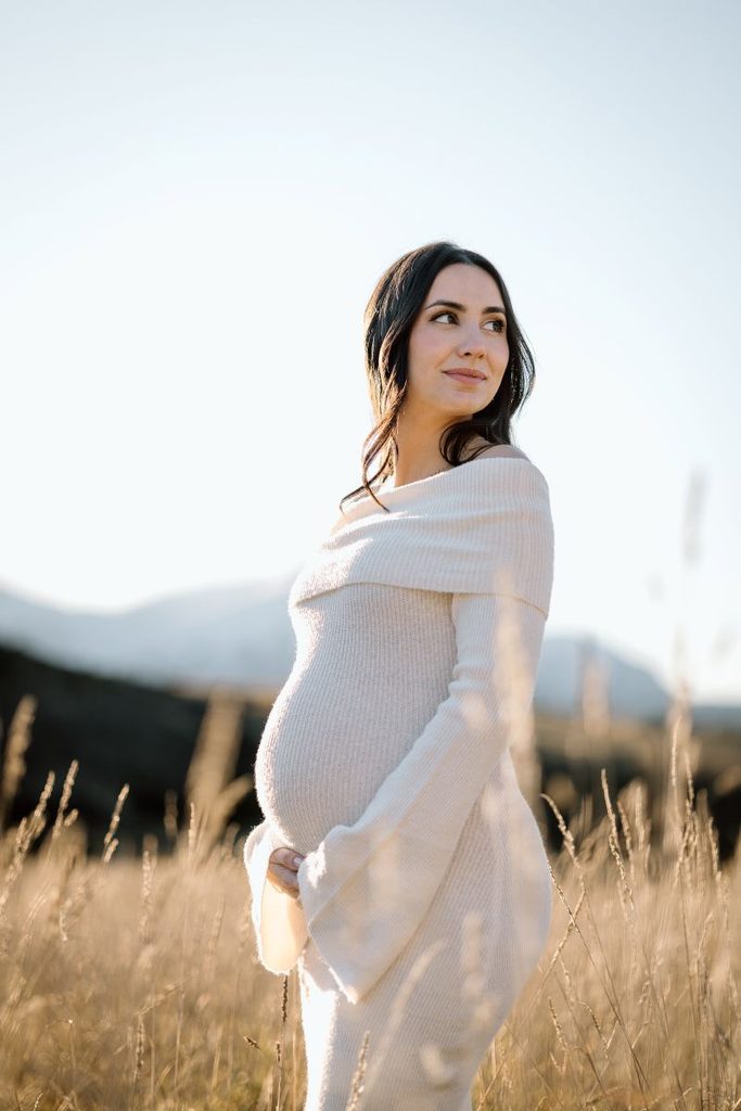 pregnant lady posing in a field in Queenstown during here maternity photoshoot.