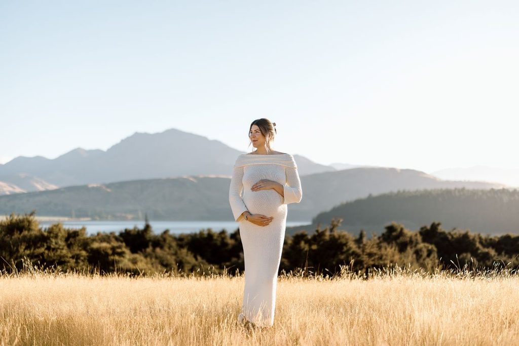 pregnant woman in the field for her maternity shoot at Jason's Clearing in Wanaka, New Zealand.
