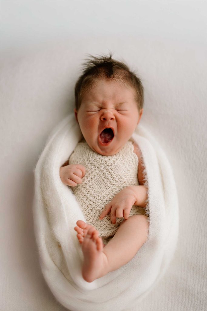 newborn baby yawning during newborn photoshoot in Lake Hawea home studio of Captured by Bie 