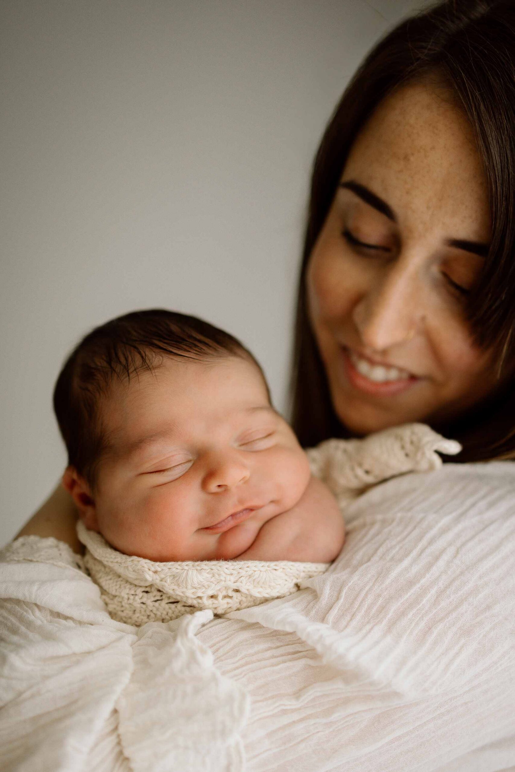 mum with newborn baby wrapped in blanket during a newborn photoshoot in wanaka